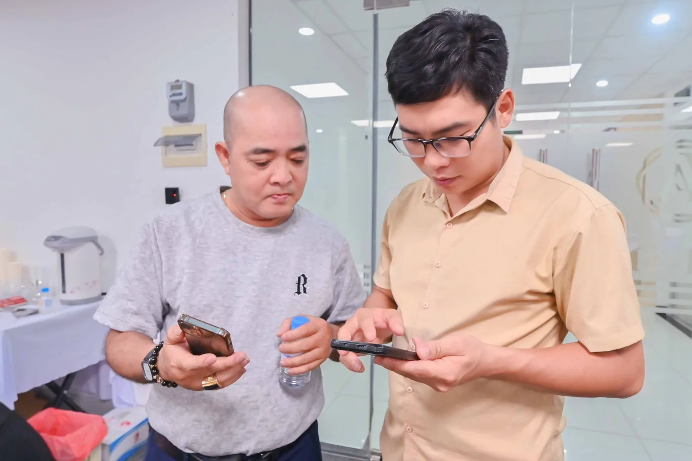 Hai người cùng xem điện thoại trong giờ thực hành
