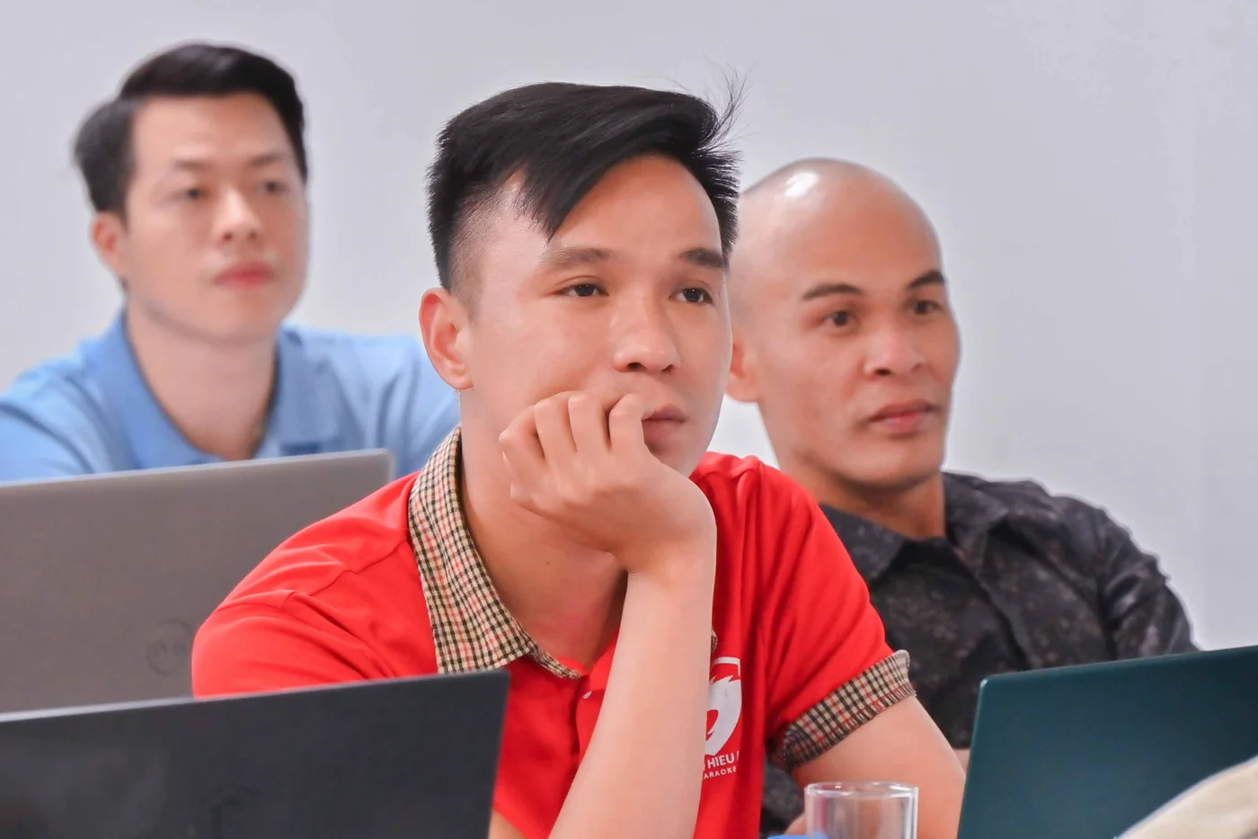 Học viên ngồi trong lớp, tay chống cằm, đang nghĩ về câu hỏi vừa nghe